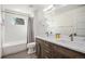 Bathroom boasts double vanity with modern fixtures, white countertops, and a bathtub with shower at 5086 N Raleigh St, Denver, CO 80212