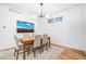 Well-lit dining room with a modern chandelier, neutral colored walls, and a wooden table with six chairs at 5086 N Raleigh St, Denver, CO 80212