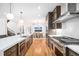 Bright kitchen featuring stainless steel appliances, custom cabinetry, and an open layout to the dining area at 5086 N Raleigh St, Denver, CO 80212