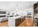 Spacious kitchen island with quartz countertops, wooden cabinets, and stainless steel appliances in an open-concept living area at 5086 N Raleigh St, Denver, CO 80212