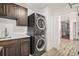 Convenient laundry room with stackable washer and dryer, custom cabinets, and a utility sink at 5086 N Raleigh St, Denver, CO 80212