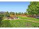 Beautiful backyard features a fire pit, mature trees, green grass, and wood fence at 859 Equinox Dr, Erie, CO 80516