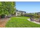 Large backyard with grass area, fire pit area, and mature trees at 859 Equinox Dr, Erie, CO 80516
