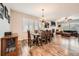 Open-concept dining area with a modern chandelier and hardwood floors, leading to the living room at 859 Equinox Dr, Erie, CO 80516