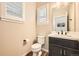 Bright powder room with modern vanity, dark cabinets, and plantation shutters at 859 Equinox Dr, Erie, CO 80516