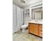 A well-lit bathroom with a shower-tub combo, and a wood vanity at 8050 Bryant St, Westminster, CO 80031