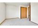 Neutral carpeted bedroom featuring wood trim, light-colored walls, and a closet with sliding wood doors at 8050 Bryant St, Westminster, CO 80031