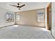 A bedroom with neutral walls and carpet, multiple windows, and a ceiling fan at 8050 Bryant St, Westminster, CO 80031