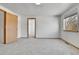 Bedroom featuring a window, neutral carpeting, and multiple access doors with wood trim at 8050 Bryant St, Westminster, CO 80031