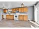 A sunlit kitchen featuring wood cabinets, modern appliances and wood-look tile flooring at 8050 Bryant St, Westminster, CO 80031