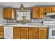 Functional kitchen featuring wood cabinets, white appliances, and lots of natural light at 8050 Bryant St, Westminster, CO 80031