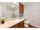 Well-lit bathroom with vanity, sink, mirror, and a toilet with wood flooring at 10056 W Unser Dr # 106, Littleton, CO 80127
