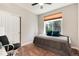 Cozy bedroom with a twin bed, ceiling fan, and natural light from the window at 10056 W Unser Dr # 106, Littleton, CO 80127