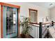 Hallway with an exercise room, indoor plant, and dark staircase railing at 10056 W Unser Dr # 106, Littleton, CO 80127