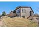 The backyard has a brown lawn, stone wall, covered patio, and windows looking into the house at 2363 S Lupine Way, Denver, CO 80228