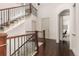 Elegant foyer featuring hardwood floors, staircase with wrought iron spindles, and an arched doorway at 2363 S Lupine Way, Denver, CO 80228