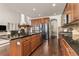 Open kitchen with stainless appliances, island with bar seating, and hardwood floors at 2363 S Lupine Way, Denver, CO 80228