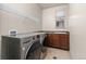 Bright laundry room featuring modern washer and dryer, a window, and ample cabinet space at 2363 S Lupine Way, Denver, CO 80228