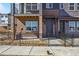 Townhome entrance with brick accents, storm door and decorative stone landscaping at 6840 Merseyside Ln, Castle Pines, CO 80108