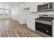 Modern kitchen features stainless steel appliances, sleek white cabinets, and wood-look flooring at 6840 Merseyside Ln, Castle Pines, CO 80108