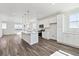 Open kitchen and living area with a large island, modern appliances, and wood flooring at 6840 Merseyside Ln, Castle Pines, CO 80108