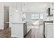 Stylish kitchen island featuring stainless appliances, white cabinetry, and hardwood floors at 6840 Merseyside Ln, Castle Pines, CO 80108