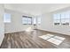 Bright living room with hardwood floors, large windows, and a walk-out deck at 6840 Merseyside Ln, Castle Pines, CO 80108