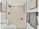 Modern bathroom with a tiled shower, built-in shelves, and sleek fixtures at 2701 Barnhart St, Thornton, CO 80229