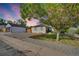 Exterior view of home with gray paint, a well-maintained yard, a detached garage, and alley access at 2701 Barnhart St, Thornton, CO 80229