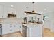 Modern kitchen with stainless steel appliances, white cabinets, quartz countertop island, and barstool seating at 2701 Barnhart St, Thornton, CO 80229