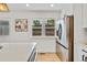 Bright kitchen features stainless steel appliances, white cabinets and countertops, and natural light at 2701 Barnhart St, Thornton, CO 80229