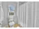 This bathroom features a toilet, a shower with patterned curtain, and a window with a view at 791 Elk Rest Rd, Evergreen, CO 80439