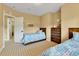 Bright bedroom featuring twin beds, tan walls, striped carpet, and natural light through an open doorway at 791 Elk Rest Rd, Evergreen, CO 80439