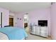 Bedroom featuring pink walls, light carpet, and a large dresser; bathroom is visible through an open doorway at 791 Elk Rest Rd, Evergreen, CO 80439