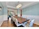 Formal dining area with chandelier lighting, wainscoting, and an open view to the living room at 791 Elk Rest Rd, Evergreen, CO 80439
