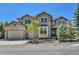 Charming two-story home with stone and stucco exterior, three-car garage, and landscaped front yard at 791 Elk Rest Rd, Evergreen, CO 80439