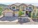 Elegant home with a combination of stone and siding, landscaping, three-car garage and mountain views at 791 Elk Rest Rd, Evergreen, CO 80439