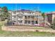 The back of the house features stone and siding with a partially covered patio, hot tub, and solar panels at 791 Elk Rest Rd, Evergreen, CO 80439