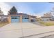 Two-car garage with light blue doors and a wide driveway at 1338 Aspen Pl, Longmont, CO 80501