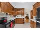 Kitchen with wood cabinets, black appliances, and a breakfast nook at 1338 Aspen Pl, Longmont, CO 80501