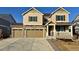 Two-story house with tan siding, three-car garage, and a small front yard at 25041 E 38Th Ave, Aurora, CO 80019