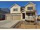 Two-story house with tan siding, three-car garage, and a small front yard at 25041 E 38Th Ave, Aurora, CO 80019