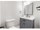 Bright bathroom featuring a modern gray vanity, matte black fixtures, clean toilet and stylish mirror providing a comfortable atmosphere at 3999 W Chenango Ave, Littleton, CO 80123