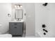 This newly renovated bathroom features a gray vanity, modern fixtures, and a tiled shower for a sleek and modern feel at 3999 W Chenango Ave, Littleton, CO 80123