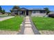 Beautiful front yard with a stone pathway leading to a well-maintained home at 3999 W Chenango Ave, Littleton, CO 80123