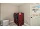 A modern laundry room with red washer and dryer, ample lighting and a door leading to the back yard at 3999 W Chenango Ave, Littleton, CO 80123
