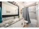 Bathroom features a modern vanity with granite counters and a shower-tub with gray tiled walls at 12051 E Lake Cir, Greenwood Village, CO 80111
