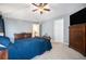 A bedroom with light blue paint, a ceiling fan, dresser and a dark wood bedroom set at 12051 E Lake Cir, Greenwood Village, CO 80111