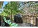 Relaxing deck with chairs and gas BBQ, surrounded by trees and greenery at 12051 E Lake Cir, Greenwood Village, CO 80111