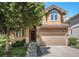 Charming two-story home with a well-manicured lawn and inviting entrance, featuring an attached two-car garage at 12051 E Lake Cir, Greenwood Village, CO 80111